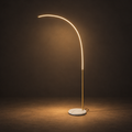 Arc Reading Lamp illuminated against a warm charcoal gallery background