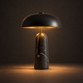 Nero Marble Table Lamp illuminated against a warm charcoal gallery background