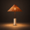 Okinawa Woven Table Lamp illuminated against a warm charcoal gallery background